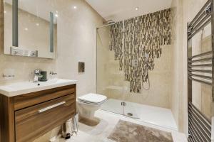 uma casa de banho com um lavatório, um WC e um chuveiro em Marylebone - MCR Residences em Londres