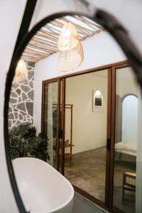 a mirror in a bathroom with a bath tub at Nagi cottage in Kinh Dinh