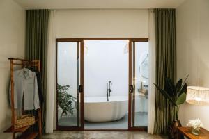 a bathroom with a bath tub in a room at Nagi cottage in Kinh Dinh