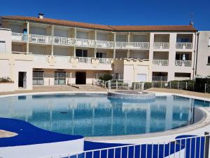 a large swimming pool in front of a building at Appartement près de la plage - 4 pers, piscine ouverte, parking, animaux acceptés - FR-1-706-12 in Châtelaillon-Plage