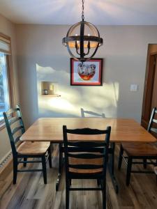 une table à manger avec des chaises et un lustre dans l'établissement The Badger House ~ Newly Remodeled Home ~ Rib Mountain, à Wausau