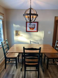 a dining room table with chairs and a chandelier at The Badger House ~ Newly Remodeled Home ~ Rib Mountain in Wausau