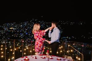 Un uomo e una donna in piedi sopra un tavolo di De Cantera Y Plata Hotel Boutique a Taxco de Alarcón