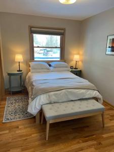 a bedroom with a bed with two tables and a window at The Badger House ~ Newly Remodeled Home ~ Rib Mountain in Wausau