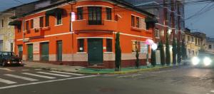 an orange building on the side of a street at HOSTAL CALIFORNIA STAR QUITO in Quito +10 photos