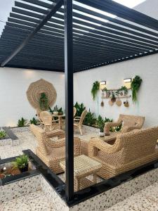 un patio con sillas de mimbre y una mesa en شاليه مُهرة, en Al Khabrāʼ