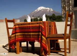 a table with two cats on it with a mountain in the background at Hotel San Andrés in San Andrés