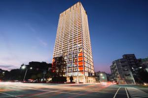 嘉义市voco Chiayi by IHG的夜晚城市街道上的一栋高楼