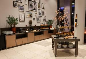 a kitchen with a counter with pictures on the wall at Leonardo Royal Hotel Amsterdam in Amsterdam