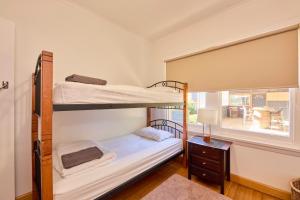 two bunk beds in a room with a window at Basin Road Townhouse in Royal Park