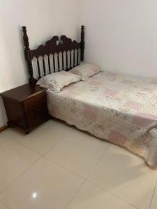 a bedroom with a bed and a wooden nightstand at Room in Achada São Filipe, Praia in Praia
