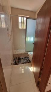 a bathroom with a toilet and a glass door at Room in Achada São Filipe, Praia in Praia