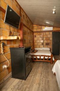Zimmer mit einem Bett und einem Flachbild-TV in der Unterkunft Posada Campestre Ecoturística Granja Julieth in San José del Guaviare