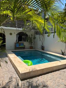 a swimming pool with a green oogie board in it at Casa Makoi in Tamanique