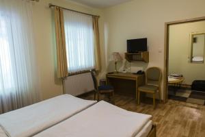 a hotel room with two beds and a desk and a mirror at Hotel Waldesruh in Georgsmarienhütte