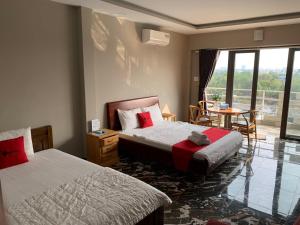 ein Schlafzimmer mit zwei Betten und einem Tisch und einem Fenster in der Unterkunft Bờ Sông Hotel in Ho-Chi-Minh-Stadt