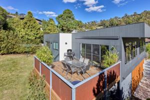 a house with a deck with a table and chairs at The Gorge Townhouse, stunning home & location! in Royal Park
