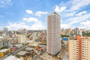 ein hohes weißes Gebäude mitten in einer Stadt in der Unterkunft Flat confortavel com cozinha, e piscina in Osasco