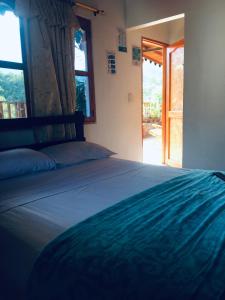 a bedroom with a large bed with a window at Hostal Los Wichos in Minca