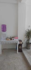 een bank in een kamer met een tafel en een plant bij CarandangFam Inn in El Nido