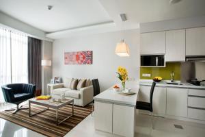 a kitchen and living room with a couch and a table at Citadines Uplands Kuching in Kuching