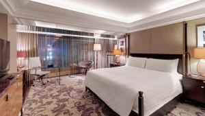 فندق إندونيسيا كمبينسكي جاكرتا في جاكرتا: غرفة فندق بسرير ومكتب وغرفة نوم