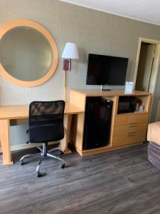 Zimmer mit einem Schreibtisch, einem Stuhl und einem Spiegel in der Unterkunft FALLS INN in Newton Falls