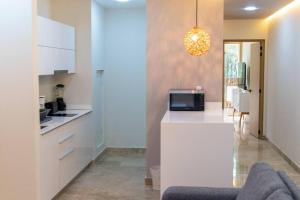 a kitchen with a white counter with a microwave at Gaia Luxurious, Comfortable and Well located AC Wi-Fi in Tulum
