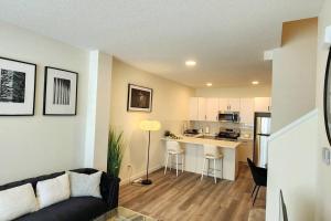 a living room with a couch and a kitchen at Modern entire 3 bedroom home in downtown Edmonton in Edmonton