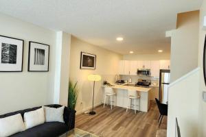 a living room with a couch and a kitchen at Modern entire 3 bedroom home in downtown Edmonton in Edmonton