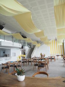 a restaurant with wooden tables and chairs and ceilings at Pronoia Beach Resort in Jimbaran