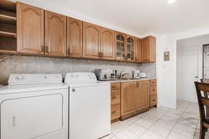 een keuken met houten kasten en een witte vaatwasser bij 2 bedroom apartment in Lasalle - 72A in Montreal
