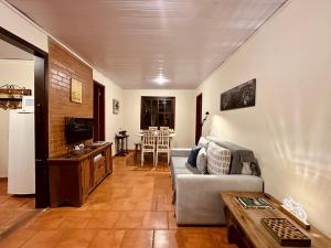 a living room with a couch and a table at Recanto da Floresta - Casa de campo em Secretário in Petrópolis