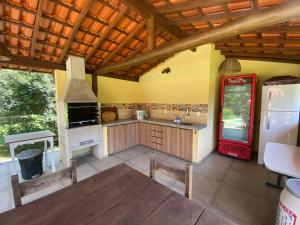 a large kitchen with a stove and a refrigerator at Recanto da Floresta - Casa de campo em Secretário in Petrópolis