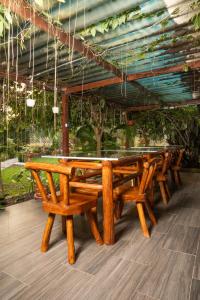 a row of wooden benches sitting under a roof at Posada Campestre Ecoturística Granja Julieth in San José del Guaviare