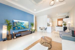 a living room with a large screen tv on a wall at Baan Promphan Premium in Phuket Town