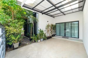 un patio intérieur avec des plantes et un plafond en verre dans l'établissement Baan Promphan Premium, à Phuket