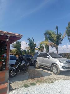 a motorcycle parked next to a silver car at Finca con Piscina Privada/Jacuzzi/Asador in San Vicente