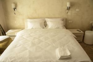 a white bed with a towel on top of it at Apartment Venera A&M in Šabac
