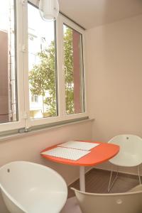 une chambre avec une planche de surf sur une table et deux chaises dans l'établissement Apartment Venera A&M, à Šabac
