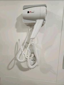a white hair dryer and a phone on a wall at Hisort Piramide Natal in Natal
