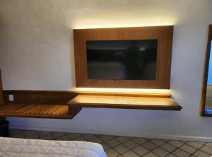 una TV a schermo piatto a parete in una camera da letto di Hisort Piramide Natal a Natal