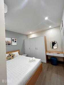 a bedroom with a large white bed and a mirror at FREE Airport pick-up FLC APT Pham Hung 2Br Apartment in Hanoi