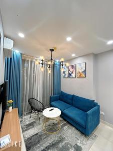 sala de estar con sofá azul y mesa en Asahi Luxstay - FLC Green Home Pham Hung 2Br Apartment, en Hanói