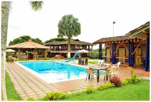 una casa y una piscina con mesa y sillas en FINCA HOTEL JARDIN CAFETERO DEL QUINDIO, en Quimbaya