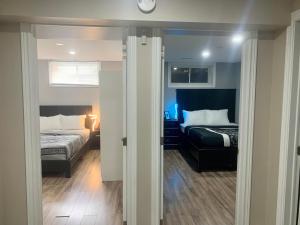 1 room in a cozy and beautiful basement في غيلف: غرفة نوم بسريرين وساعة على الحائط
