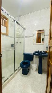 y baño con aseo azul y lavamanos. en FINCA HOTEL JARDIN CAFETERO DEL QUINDIO, en Quimbaya
