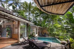 a patio with a swimming pool and a house at Pramana Giri Kusuma in Payangan