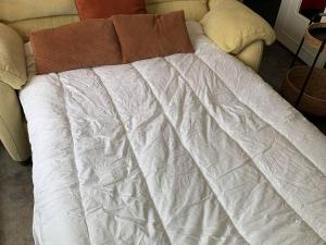 ein Bett mit einer weißen Bettdecke darüber in der Unterkunft Appartement Cabourg, 2 pièces, 4 personnes - FR-1-465-107 in Cabourg