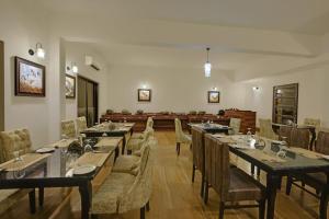 a dining room with long tables and chairs at The Hunting Lodge Resort Udaipur - Villas & Pool in Dabok